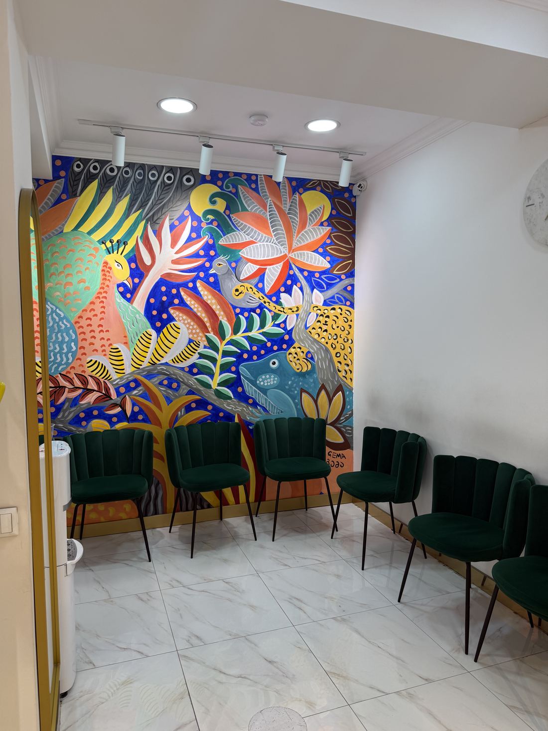 Waiting lounge with a painted mural and green chairs